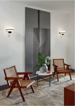  ??  ?? THIS PAGE
The entry hall features Pierre Jeanneret armchairs, a Ned Vena artwork and wall lights by Gino Sarfati; artworks by Pierre Le-tan add a touch of whimsy to the dining area; the kitchen cabinetry was selected to match the Pierre Jeanneret armchairs and table