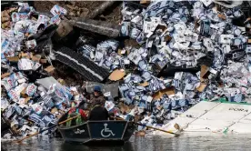  ?? Photograph: Ben Allan Smith/AP ?? A group of fishermen claim a bottle of beer from a derailment on the banks of the Clark Fork River on Sunday. No one was injured.