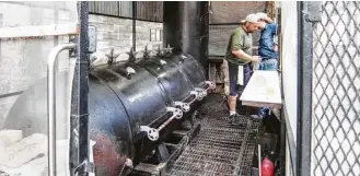  ?? J.C. Reid photos ?? Tejas Chocolate Craftory uses an offset barrel smoker, an example of a manual barbecue pit.