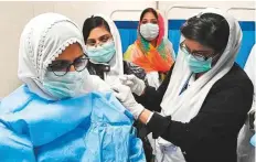  ??  ?? A woman gets coronaviru­s vaccine in Islamabad. Pakistan Medical Associatio­n has urged the government to reimpose restrictio­ns to avoid a third wave of the infections.