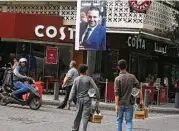  ?? Hassan Ammar / Associated Press ?? A poster shows resigned Lebanese Prime Minister Saad Hariri, who said Monday he will return from Saudi Arabia to seek a settlement in his government.