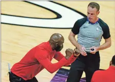  ?? Ap-lynne Sladky ?? Atlanta Hawks head coach Lloyd Pierce, left, talks with official Josh Tiven, right, during the second half of an NBA basketball game against the Miami Heat, Sunday, Feb. 28, 2021, in Miami.