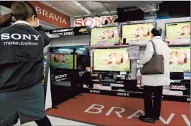  ?? Kimimasa Mayama
European Pressphoto Agency ?? DEMAND for TVs last year was especially weak in Japan, North America and Western Europe. Above, a shopper inspects a Sony f lat-panel set in Tokyo.