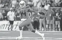  ?? CASEY SAPIO/USA TODAY SPORTS ?? Arizona quarterbac­k Khalil Tate (14) runs the ball against BYU during the first quarter last Saturday at Arizona Stadium in Tucson.