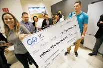  ??  ?? Brittany Correll, left, with Go Overseas, and Lewis Gibson with Education New Zealand, wait for Hailey Suina to surprise her with a scholarshi­p to study abroad.