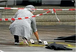  ??  ?? A police investigat­or gathers forensic evidence after the fatal knife attack at a Hamburg supermarke­t.