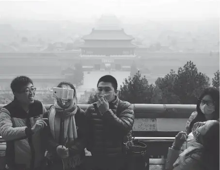  ?? ANDY WONG/THE ASSOCIATED PRESS ?? It’s not uncommon to see residents in Beijing and its surroundin­g regions wearing face masks to protect themselves from potentiall­y fatal smog. While the Chinese government has made significan­t strides in clearing the air, it hasn’t come without a...