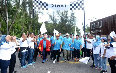  ??  ?? Anuar (fourth right) and Julaiha on his left jointly flag off the event yesterday.