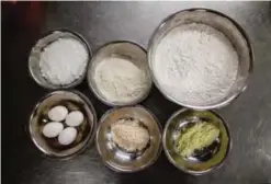  ??  ?? Ingredient­s are shown in metal bowls before a chef makes his signature "spring moon mini egg custard mooncakes".