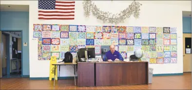  ?? H John Voorhees III / Hearst Connecticu­t Media ?? Jim Pacific, an armed school security guard, works at the security desk in the main entrance in Reed Intermedia­te School in Newtown on Tuesday.