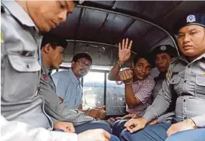  ??  ?? Reuters journalist­s Wa Lone and Kyaw Soe Oo under police escort as they leave Insein court in Yangon yesterday. REUTERS PIC