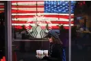  ?? Photograph: Lucas Jackson/Reuters ?? A woman carries coffee out of a Starbucks store in Manhattan.