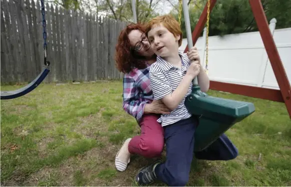  ?? STEVEN SENNE/THE ASSOCIATED PRESS FILE PHOTO ?? Susan Grenon ensures her son, Pauly, is lathered with sunscreen before he heads to school in the morning, but the red-headed 10-year-old can’t bring a bottle to reapply without a doctor’s note.