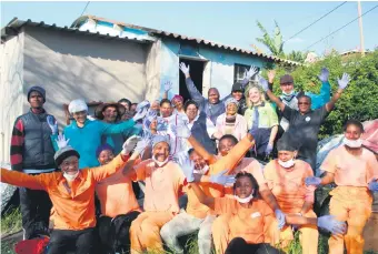  ?? Photo: Yaseen Gaffar ?? All smiles... Knysna stakeholde­rs at one of the identified houses to get a repaint in Hornlee.