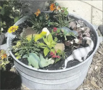  ?? ?? A DINOSAUR GARDEN is a favorite for a child infatuated with dinosaurs. Using a galvanized tub with holes drilled in the bottom for drainage makes a perfect outdoor mini-garden.