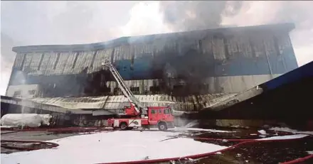  ?? PIC BY MOHD ASRI SAIFUDDIN MAMAT ?? Fire and Rescue Department personnel dousing the flames at a factory and chemical storage facility in Subang Jaya yesterday.