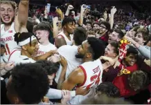  ?? AP photo ?? Maryland forward Donta Scott and teammates are swarmed by students rushing the court after Maryland defeated Purdue 68-54 Thursday.