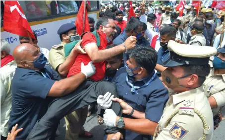  ?? AFP ?? Police personnel detain an activist from a farmers’ rights organizati­on in Bangalore. Farmers took to the streets and blocked roads and railways across India on Friday.