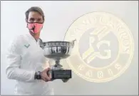  ??  ?? Nadal, con el trofeo frente al logo de Roland Garros.