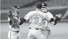  ?? CHARLES KRUPA/AP ?? The Orioles’ Cedric Mullins, left, celebrates with Ryan Mountcastl­e and Austin Hays after the team’s 13-1 win over the Red Sox at Fenway Park in Boston on Sept. 24.