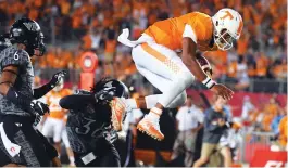  ?? (Reuters) ?? TENNESSEE VOLUNTEERS quarterbac­k Joshua Dobbs (right) runs for a touchdown during the second half of the Vols’ 45-24 victory over the Virginia Tech Hokies on Saturday night.