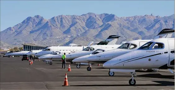  ?? Ross D. Franklin / Associated Press ?? A Scottsdale Airport staffer waits on a private jet, as the airport gears up for the expected dramatic increase in private jet traffic, leading up to Super Bowl LVII on Sunday. More than 4,000 additional takeoffs and landings at Phoenix-area airports are expected this week, according to the FAA.