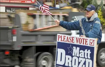  ?? Darrell Sapp/Post-Gazette ?? Matt Drozd, campaignin­g for Allegheny County executive, waves a flag on a traffic island next to the southbound lane of Route 8 in Etna on Tuesday. He faced off against incumbent Executive Rich Fitzgerald.