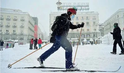  ??  ?? Sci di fondo a Puerta del Sol, una delle piazze più importanti di Madrid. Ma in Spagna la super nevicata ha causato anche molti disagi