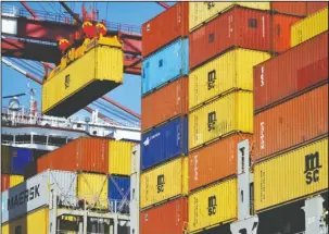  ?? The Associated Press ?? LOADING CARGO: A container is loaded onto a cargo ship on April 8 at a port in Qingdao in east China’s Shandong province. China has accused the United States on Thursday of using pressure tactics and blackmail in threatenin­g to impose tariffs on...