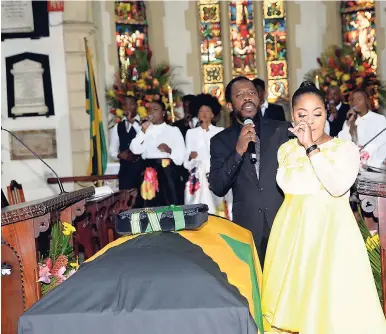  ??  ?? Kari Douglas (right), daughter of the late Easton Douglas, weeps as Wayne Marshall delivers a sombre tribute with his single ‘Glory to God’ during her father’s thanksgivi­ng service at the St Andrew Parish Church recently.