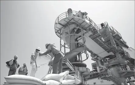  ?? PROVIDED TO CHINA DAILY ?? Employees sort grain bags at a storage facility of COFCO Eastocean Oil and Grain Industries ( Zhangjiaga­ng) Co Ltd, a COFCO unit, in September.