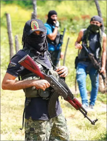  ?? ?? Armed men who claim to be members of a “self-defense” squad patrol the limits of Taixtan on Oct. 28 in Michoacan.