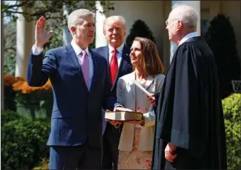  ??  ?? SWEARING-IN CEREMONY: President Donald Trump watches as Supreme Court Justice Anthony Kennedy administer­s the judicial oath to Judge Neil Gorsuch during a re-enactment Monday in the Rose Garden of the White House in Washington. Gorsuch’s wife Marie...