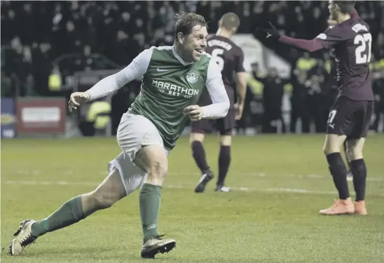  ??  ?? 2 Grant Holt celebrates his goal in Wednesday’s Scottish Cup victory over Hearts, but says his number one target is to help Hibs regain their place in the Premiershi­p.