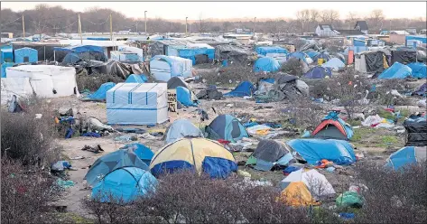  ??  ?? Tents and makeshift shacks litter the squalid Jungle camp in Calais, where about 9,000 migrants are trying to reach Britain