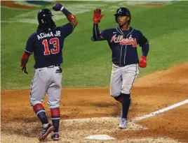  ?? AP PHOTO/ADAM HUNGER ?? Atlanta’s Ozzie Albies is congratula­ted by teammate Ronald Acuna Jr. after hitting a two-run home run for the Braves against the New York Mets during the seventh inning of the NL East rivals’ meeting Sunday night in New York. Atlanta won 14-1.