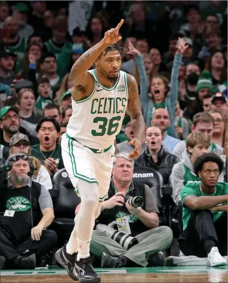  ?? STUART CAHILL — BOSTON HERALD ?? Boston Celtics guard Marcus Smart reacts after sinking a 3-pointer during a Dec. 27, 2022 game against the Rockets at the TD Garden.