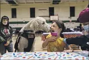  ?? David Goldman Associated Press ?? LEANNA ARCILA, 7, gets the approval of therapy dog Watson as she receives a shot in Pawtucket, R.I.