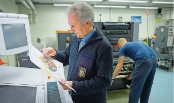  ?? FOTO: OLIVER DIETZE ?? Michael Math, Betriebsin­spektor in der Druckerei der JVA Saarbrücke­n, prüft ein Druckwerk.