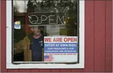  ?? TED S. WARREN — THE ASSOCIATED PRESS FILE ?? In this Jan. 4, 2021, file photo, a person walks through an entrance to the Farm Boy Drive-In restaurant during a protest rally near Olympia, Wash. The restaurant has been facing fines and penalties for continuing to offer inside dining despite current restrictio­ns on the practice in Washington state due to the coronaviru­s pandemic.