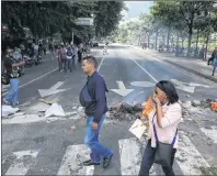  ?? AP PHOTO ?? Pedestrian­s walk past a barricade set up by anti-government demonstrat­ors, in Caracas, Venezuela, Tuesday.