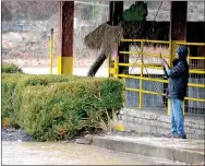  ?? KENT MARTS MCDONALD COUNTY PRESS ?? Using the Shadow Lake pavilion in Noel to get out of the rain Sunday, a man takes a photo of Butler Creek, which along with Elk River, flooded parts of downtown.