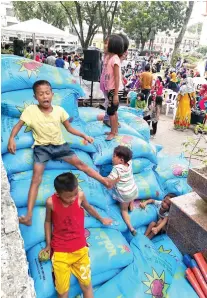  ?? SUNSTAR FOTO / ARNI ACLAO ?? RICE AND FALL. Children of families displaced from Marawi took the time to play while the Cebu City Government distribute­d sacks of rice to the evacuees.