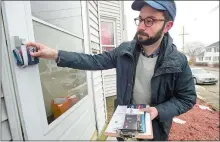  ??  ?? Campaign volunteer David Yaccarino of East Haven leaves campaign materials behind at a residence as he goes door to door Saturday in Manchester, N.H., canvassing for the presidenti­al campaign of Sen. Bernie Sanders.