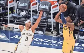  ?? RICK BOWMER/AP ?? Utah Jazz guard Donovan Mitchell (45) shoots as New Orleans Pelicans guard Josh Hart (3) defends Tuesday in Salt Lake City.