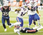  ?? ELISE AMENDOLA/ASSOCIATED PRESS ?? Stefon Diggs, middle, now Buffalo’s record-holder in singleseas­on receiving yards, runs away from New England defensive back Kyle Dugger for a touchdown Monday night in the Bills’ 38-9 rout of the Patriots.