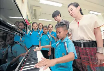  ?? APICHART JINAKUL ?? A young schoolboy at Wat Ratchanatd­a displays his piano playing skills. The piano, which cost the Bangkok Metropolit­an Administra­tion 165,000 baht for their western music class programme, has been criticised by Democrat MP Wilas Chanpithak.