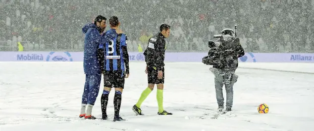  ?? (Getty Images) ?? Sotto la neve L’arbitro Maurizio Mariani di Aprilia, 36 anni, dopo aver parlato con il capitano della Juventus Gigi Buffon, 40 anni, e con quello dell’atalanta, Rafael Toloi, 27 anni, decide di rinviare la partita. Il campo era totalmente ricoperto di...