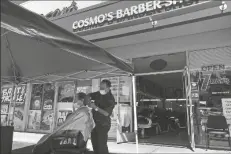  ??  ?? IN THIS SEPT. 29, 2020, FILE PHOTO, restaurant owner Samantha DiStefano (left), of Mama Fox, prepares to hand menus to patrons dining outside at her Brooklyn establishm­ent in New York. In this July 22, 2020, file photo (at right), a customer of Cosmo’s barber shop receives a haircut in the parking lot in front of the shop in Pleasanton, Calif. The coronaviru­s and the drastic measures put in place by government officials to try to control its spread had a severe toll on many small businesses in the U.S. Restaurant­s, hair salons, event planners and other businesses that rely on people being in close proximity were particular­ly hard-hit, as were those tied to tourism.