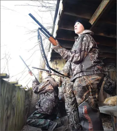  ?? NWA Democrat-Gazette/FLIP PUTTHOFF ?? Colby Shastid (right), 15, stands ready to shoot as a group of ducks comes in for a landing during the youth waterfowl hunting day on Feb. 3.